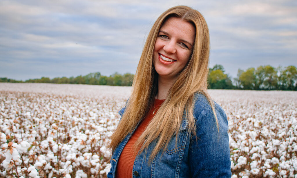 girl in a cotton field posing for senior portrait in Athens, AL
