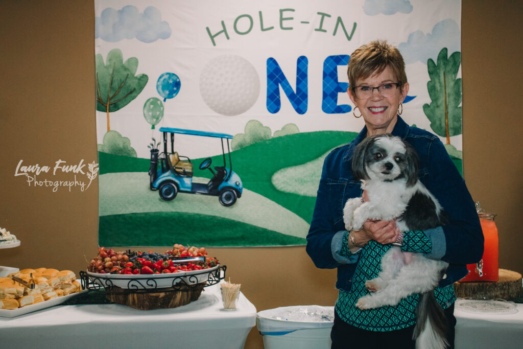 Woman holding dog at birthday party event