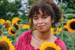a girl in sunflower field posing for her senior portrait