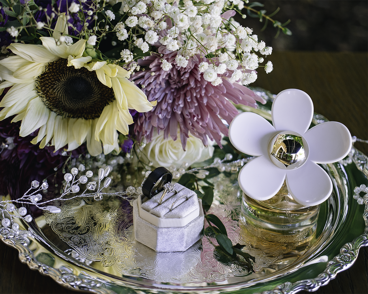 brides bouquet with wedding ring set on silver tray with perfume