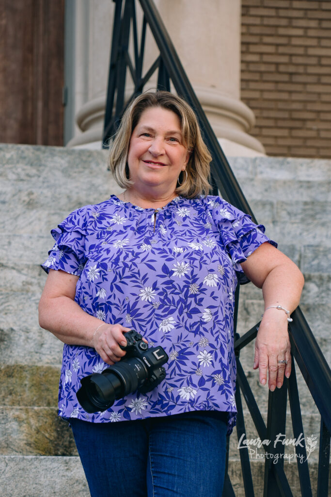 Photographer holding her camera on the staircase