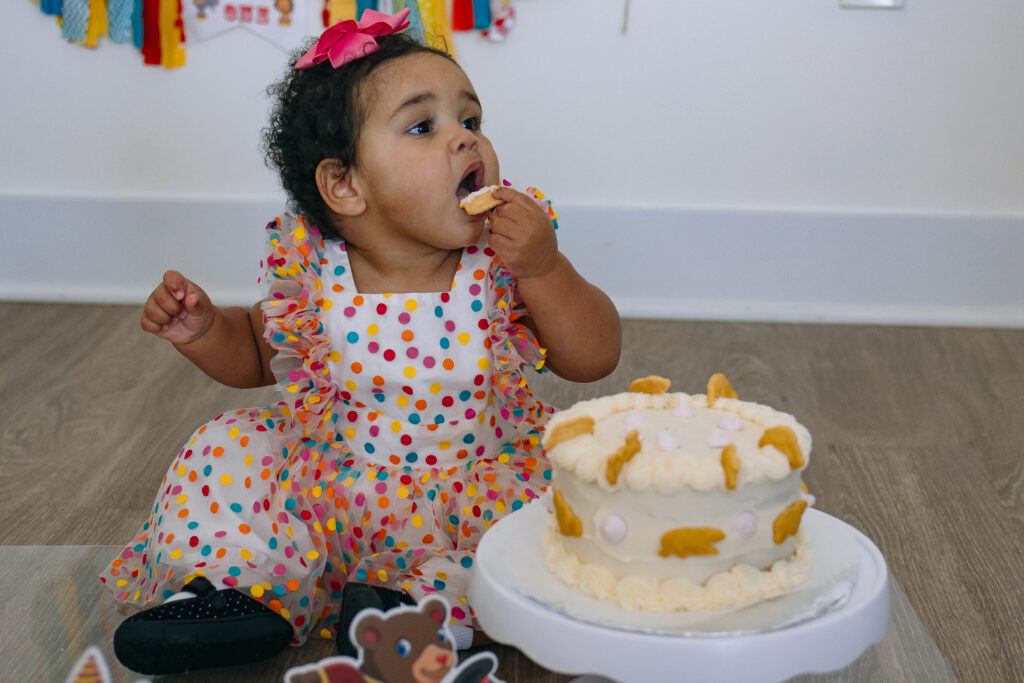 one year old girl birthday party eating cake