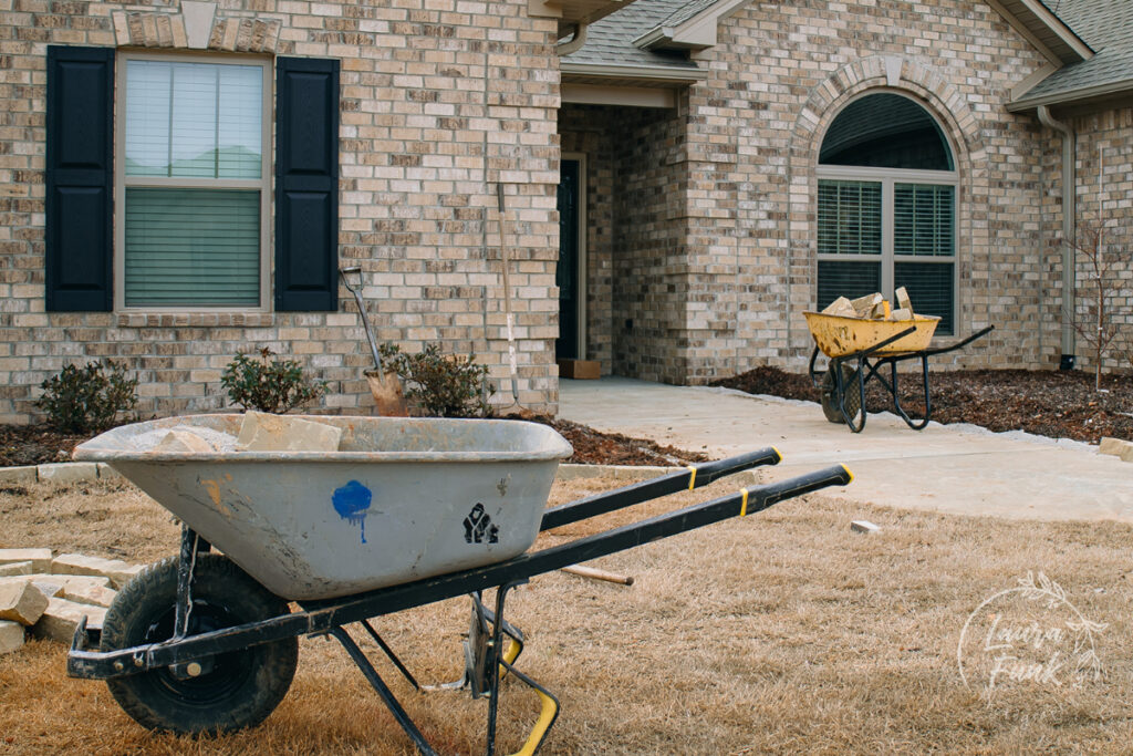 landscaping photo with two wheel barriers in the front yard