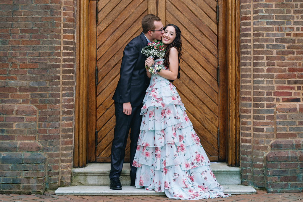 couple taking prom photos in front of a church door.